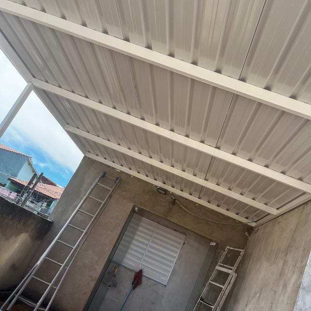 Cobertura metálica branca com estrutura vista por baixo